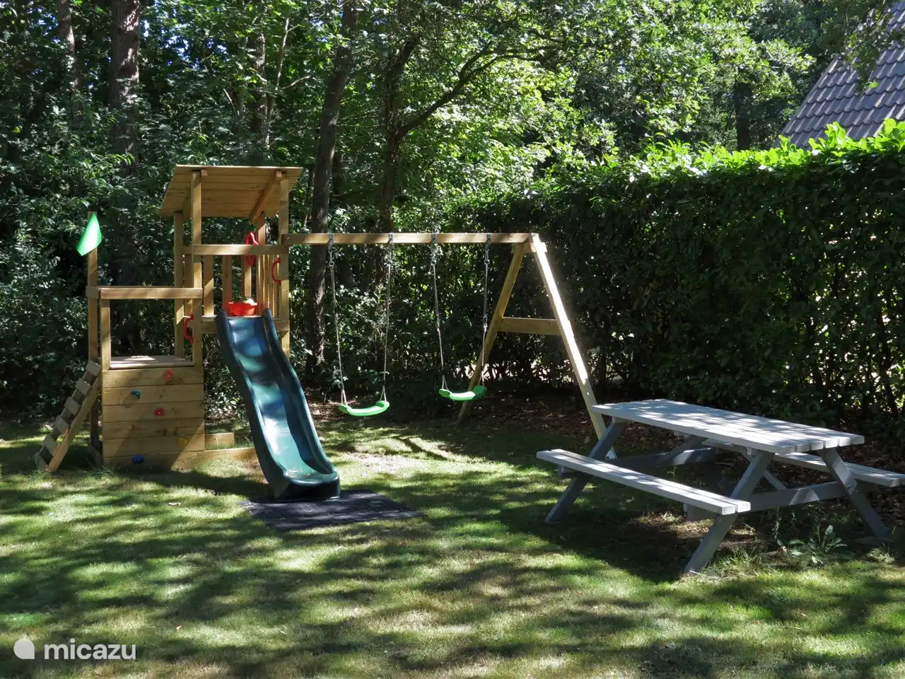 Draußen haben wir den Garten mit einem Spielplatz ausgestattet, auf dem Kinder schaukeln, klettern und die Rutsche benutzen können 