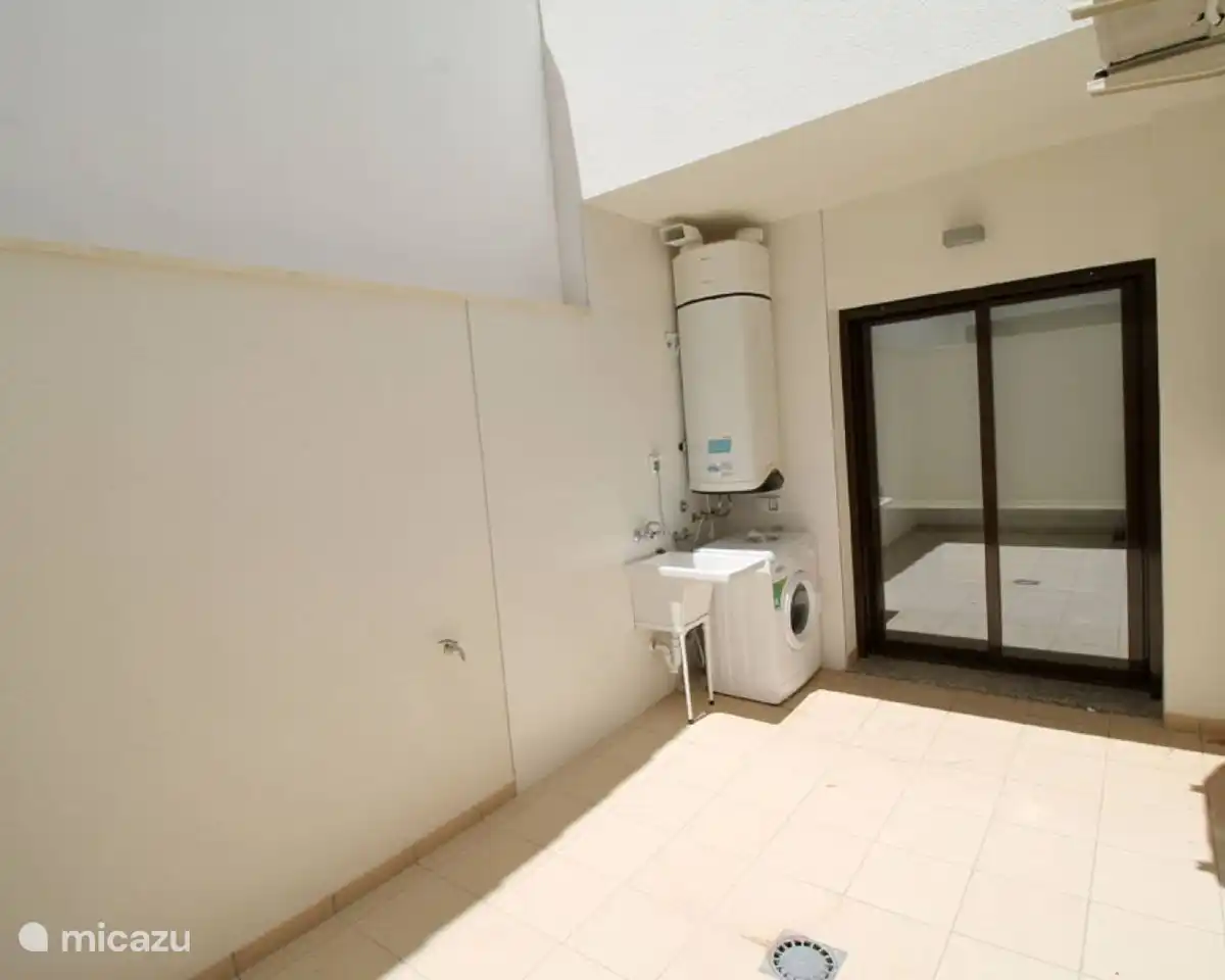 Eine Terrasse dahinter, wo sich die Waschmaschine befindet.