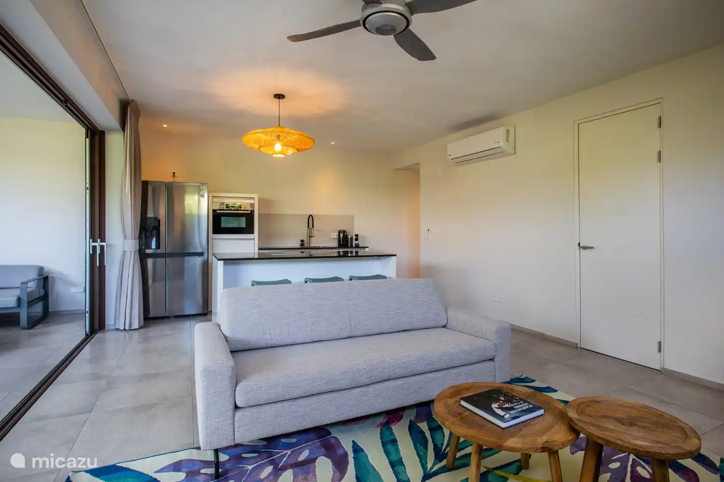 Wohnbereich im Innenbereich mit offener Küche, Flur zum zweiten Schlafzimmer und Tür zur Waschküche.