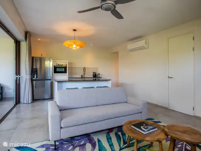 Jan Sofat LUX A08 | Curaçao, Banda Ariba (est), Jan Sofat - appartement Espace de vie intérieur avec cuisine ouverte, couloir vers la deuxième chambre et porte vers la buanderie.
