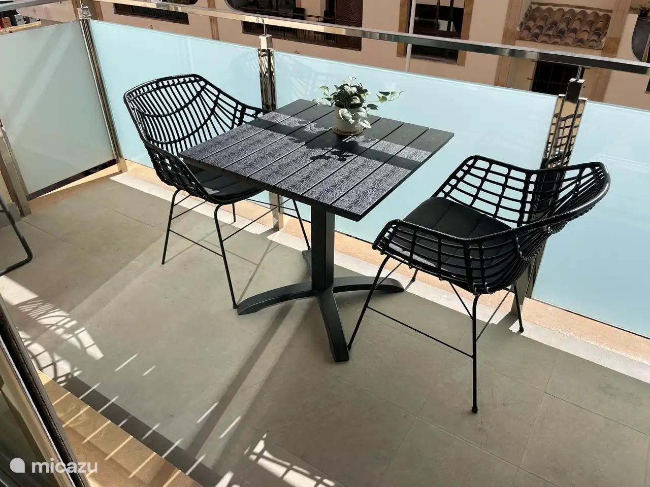 Grand balcon orienté sud avec sièges.