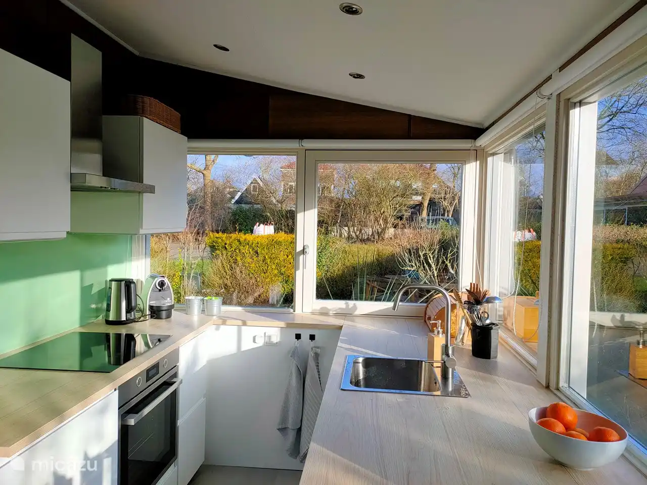 Bright kitchen surrounded by windows
dishwasher
oven/grill
fridge with freezer
4 burner induction hob
Nespresso machine and filter coffee machine
kettle
blender
sufficient crockery and cutlery
cleaning products and spices