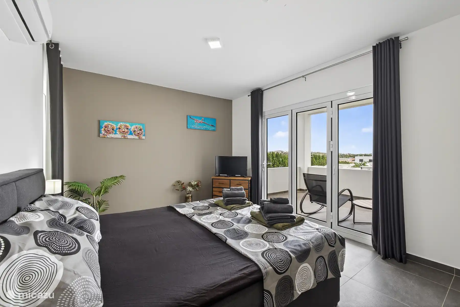 Master bedroom met schuifdeuren naar het balkon en veel natuurlijk licht.