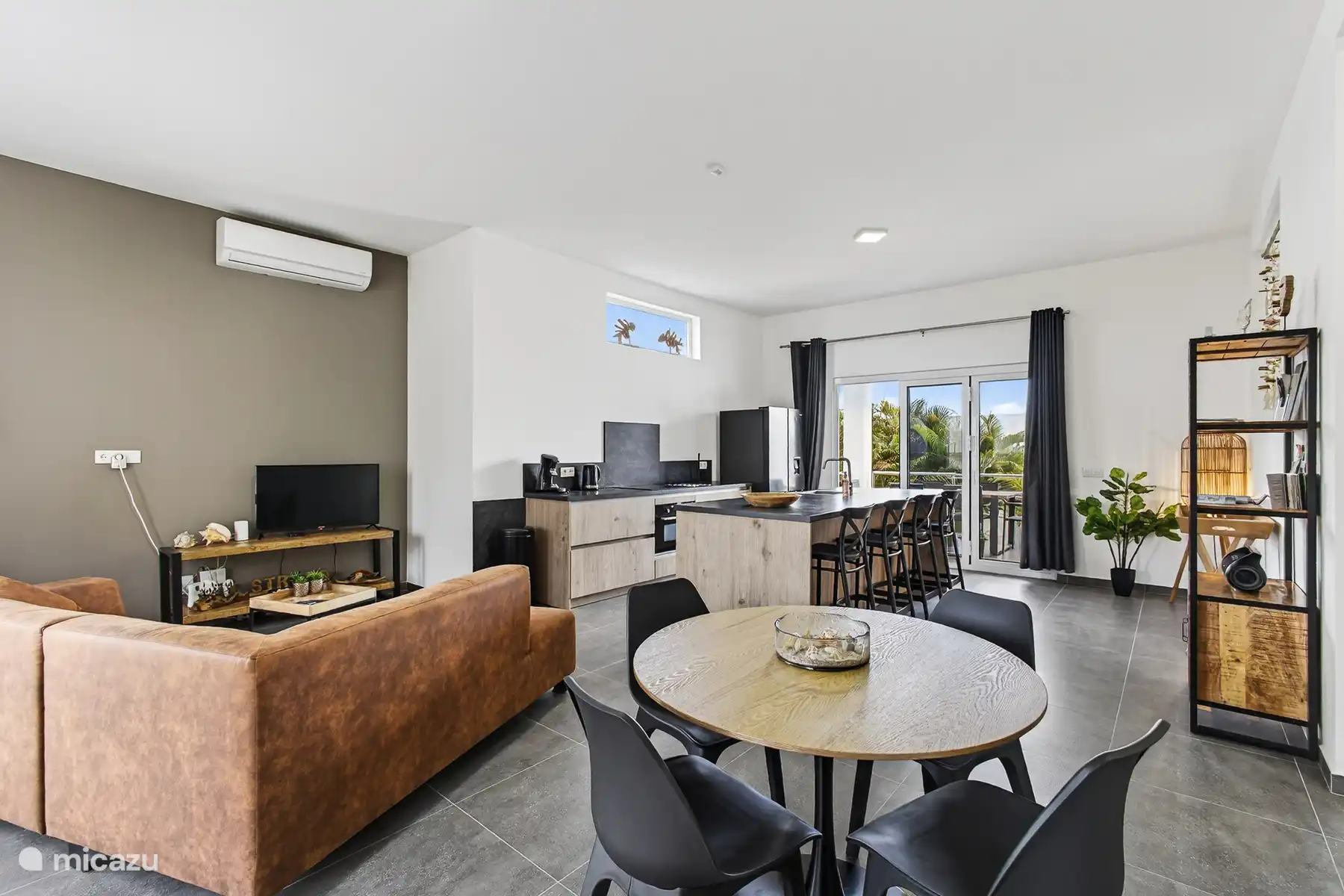 Gezellige living met zithoek en zicht op de open keuken en eetgedeelte.