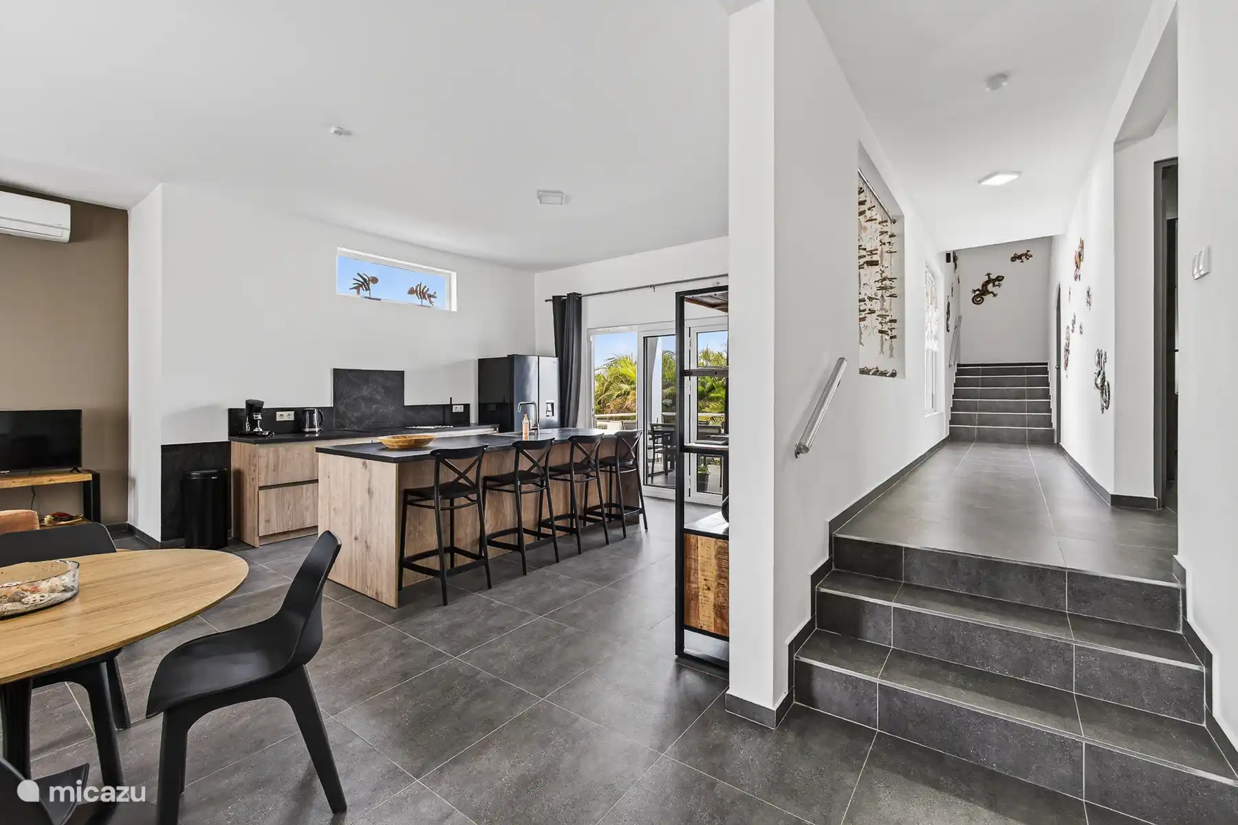 Open keuken met kookeiland, barstoelen en directe verbinding met de woonruimte.