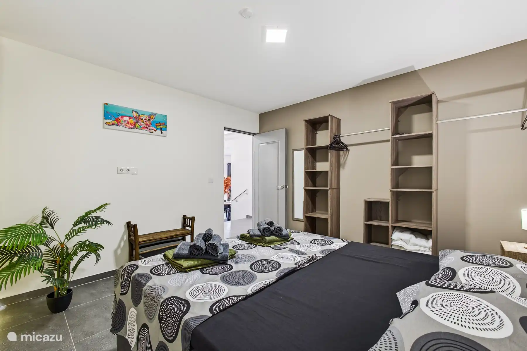 Slaapkamer met tweepersoonsbed, open kastruimte en praktische indeling.