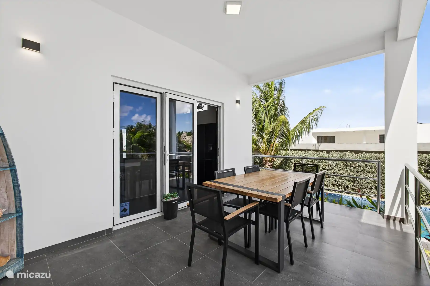 Overdekt terras met eettafel, perfect om buiten te eten en te ontspannen.