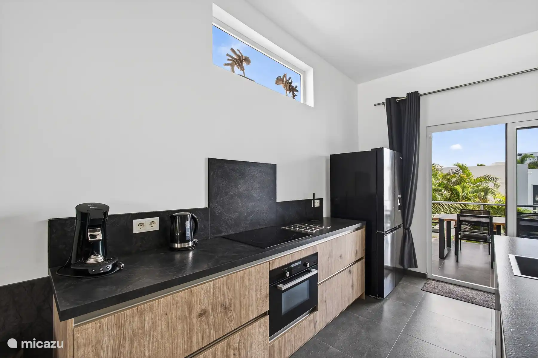 Keuken met koffiehoek, moderne apparatuur en toegang tot het terras.