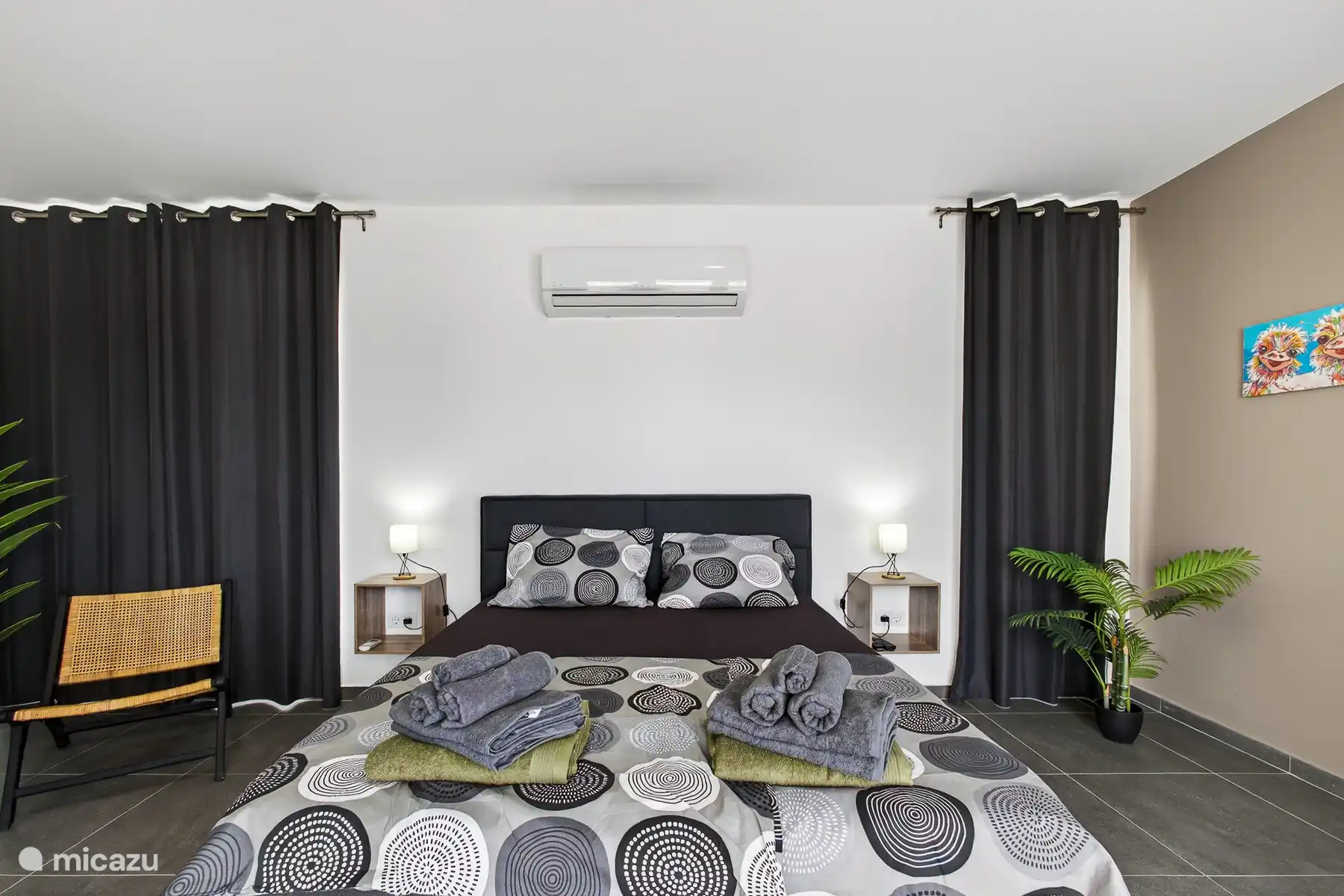 Slaapkamer met comfortabel tweepersoonsbed, airconditioning en sfeervolle verlichting.