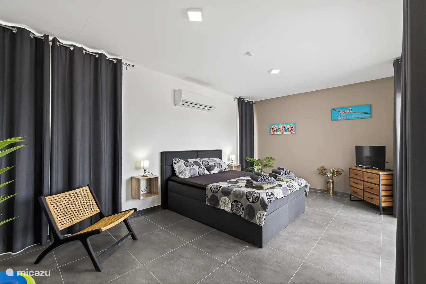 Comfortabele slaapkamer met tweepersoonsbed, airconditioning en moderne inrichting.