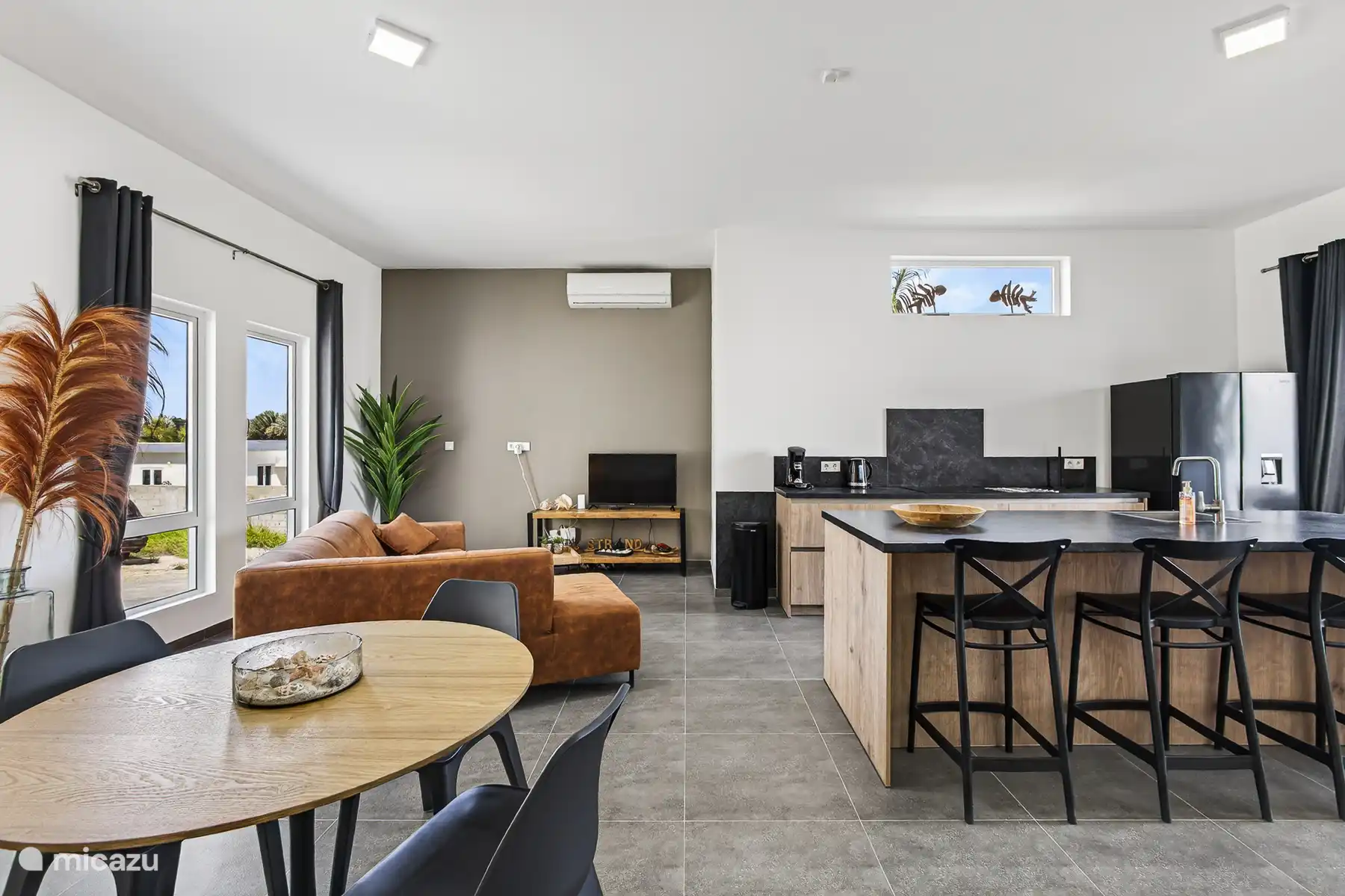 Woonruimte met zithoek, eettafel en open keuken in één lichte ruimte.