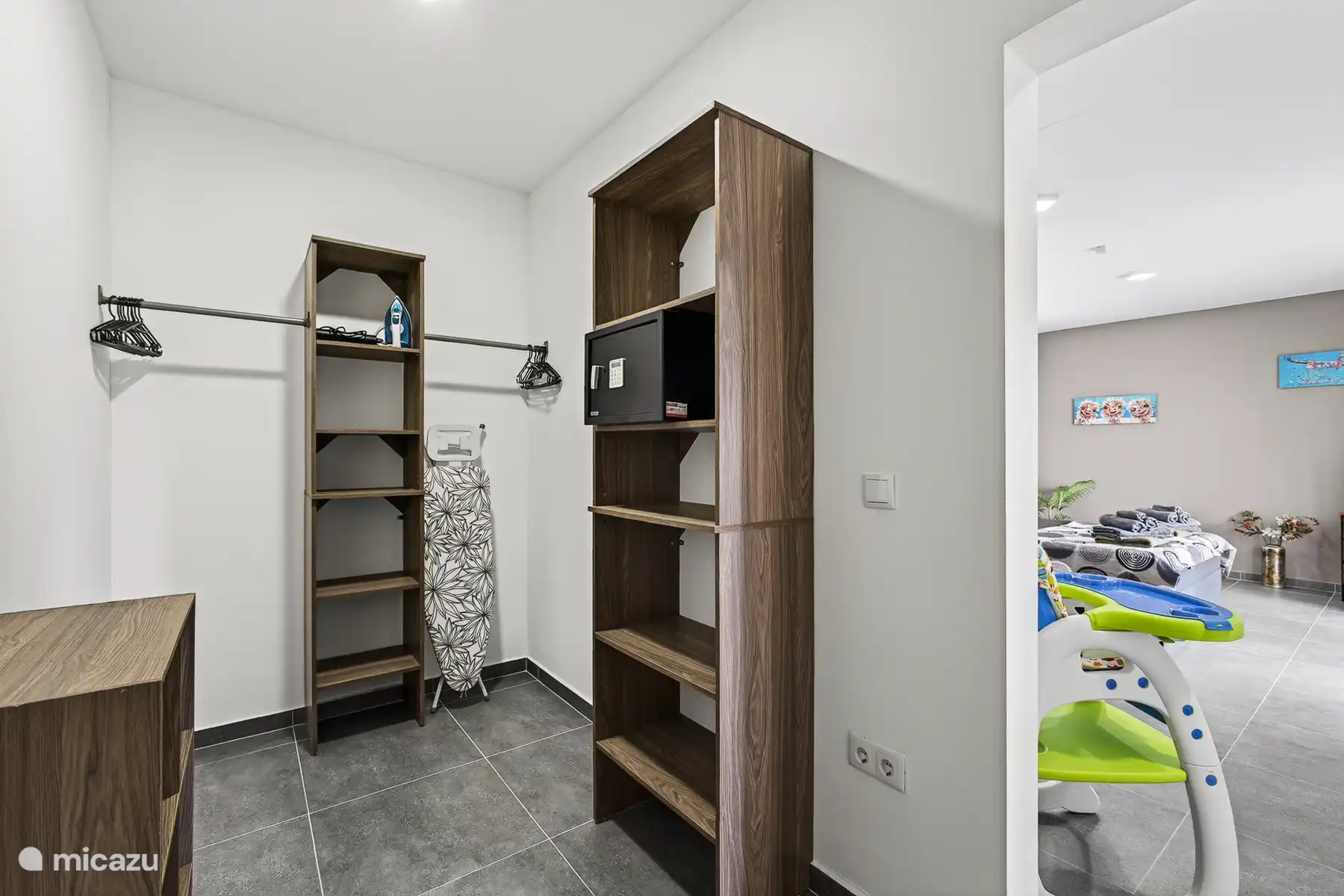 Inloopkast met open kasten, hangruimte en kluis voor persoonlijke spullen.