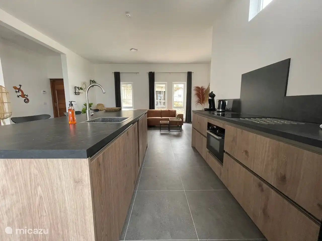 Kitchen with cooking island, dishwasher, American fridge, oven / microwave and induction hob, and air conditioning.