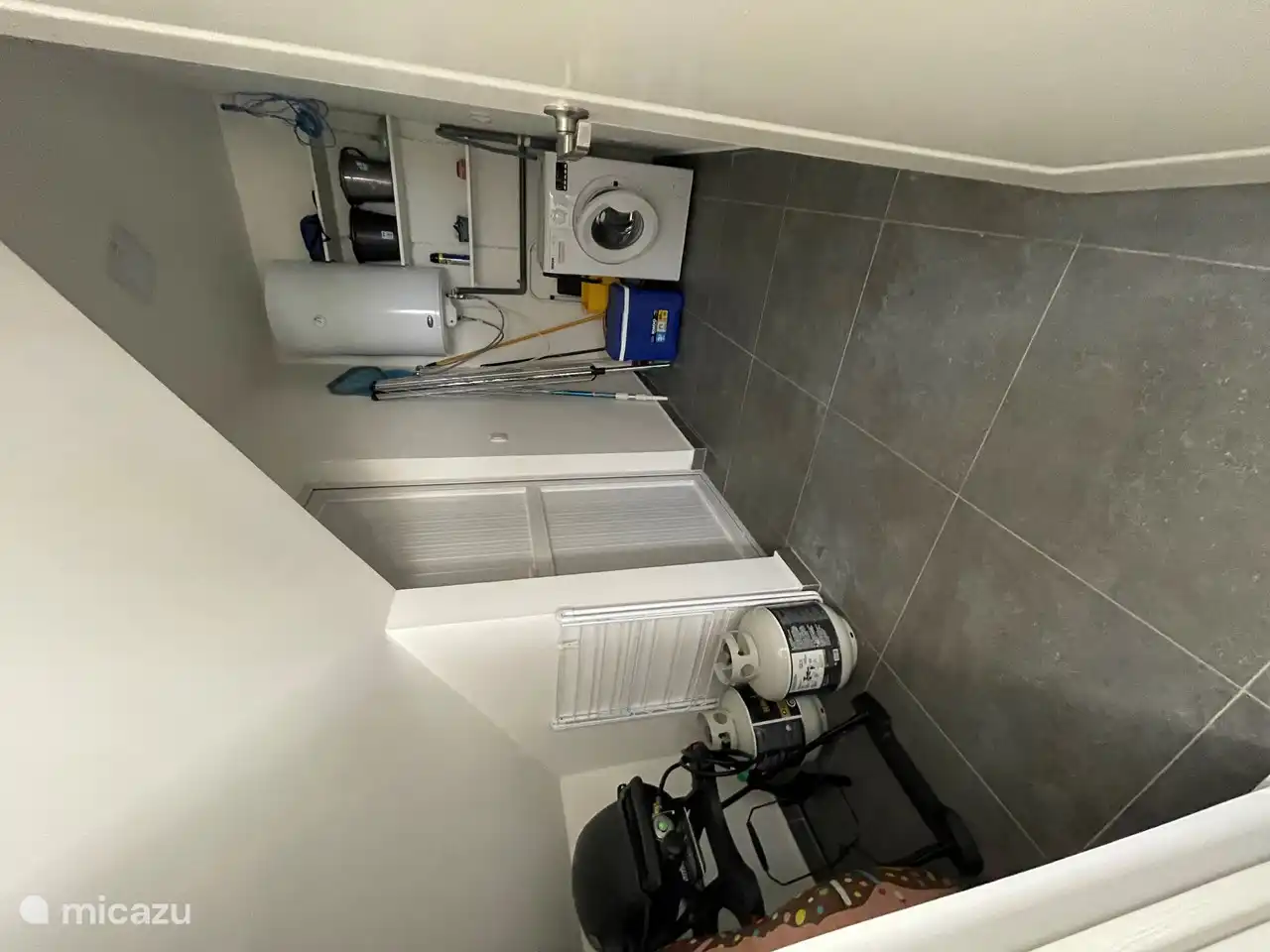 Spacious storage room with washing machine and barbecue