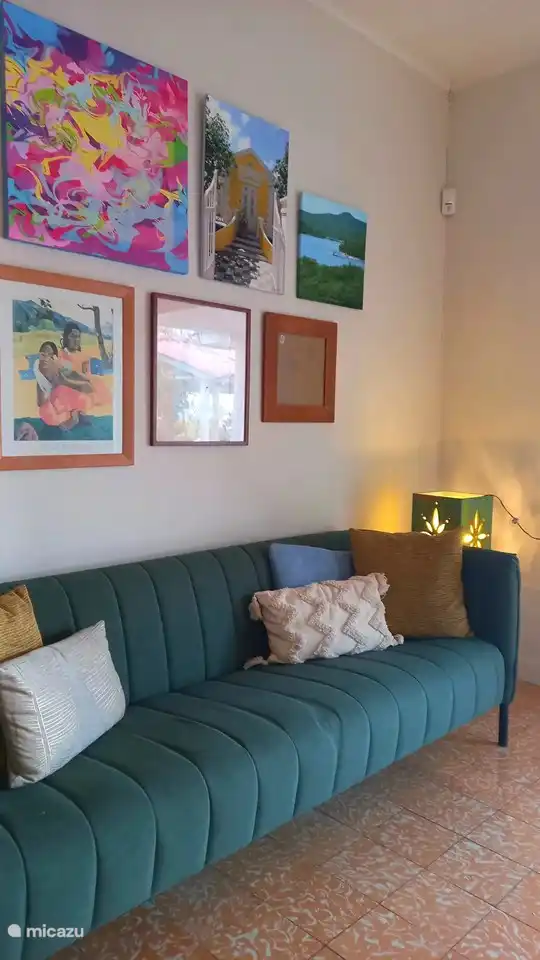 Im Wohnzimmer ist es gemütlich. Die Atmosphäre haben wir mit Pflanzen, Kunst und modernen Holzmöbeln geschaffen.