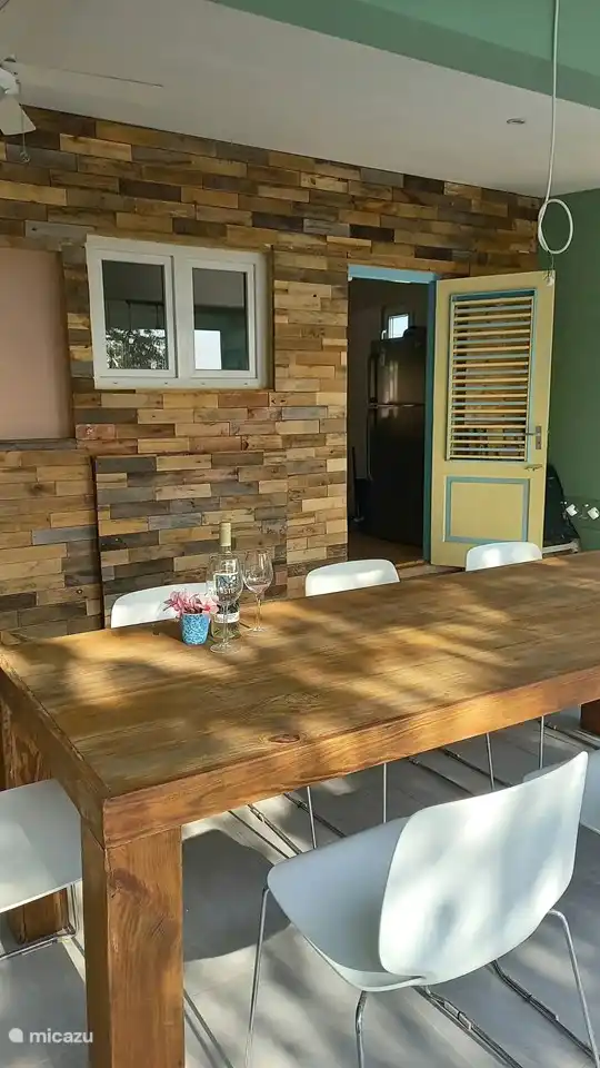 Das Haus hat eine große Veranda, die an den Garten und den Pool grenzt. Es gibt einen langen Esstisch für 8 Personen.