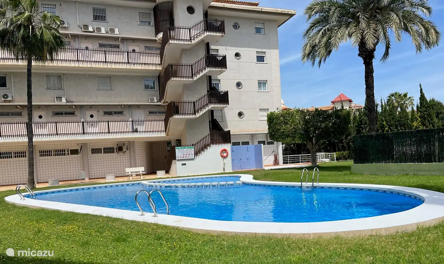 Zwembad in de tuin acherzijde gebouw.