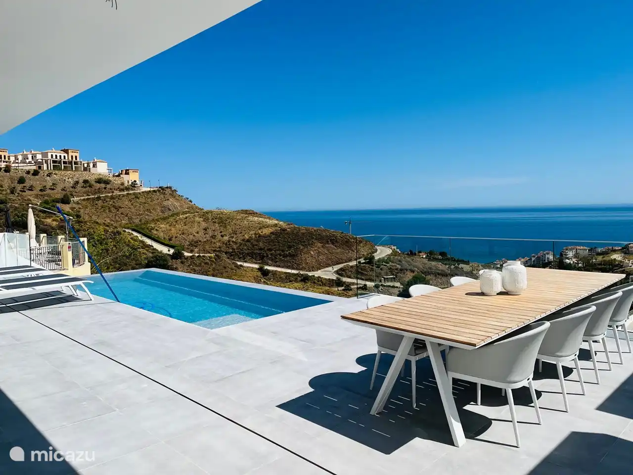 Große Terrasse mit Tisch, Stühlen und bequemen Sonnenliegen