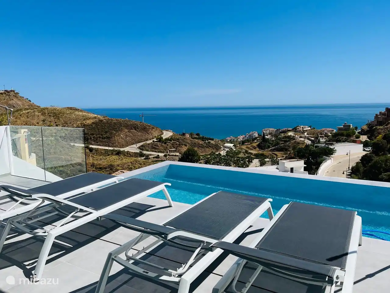 Bequeme Sonnenliegen neben dem Pool