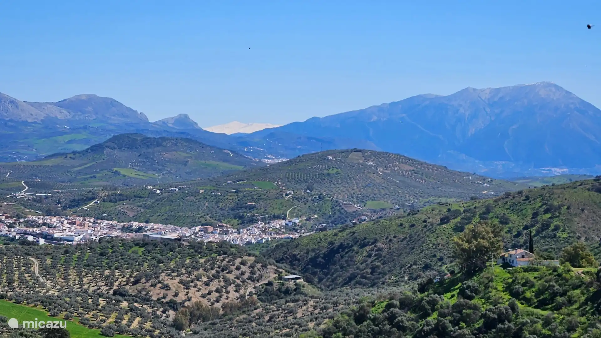 Blick von der großen Terrasse auf Riogordo, La Maroma und in der Ferne den Schnee der Sierra Nevada