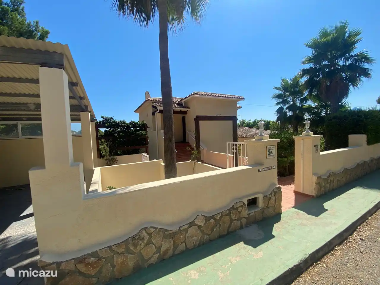 Frente de la casa con la marquesina a la izquierda con espacio para 4 autos