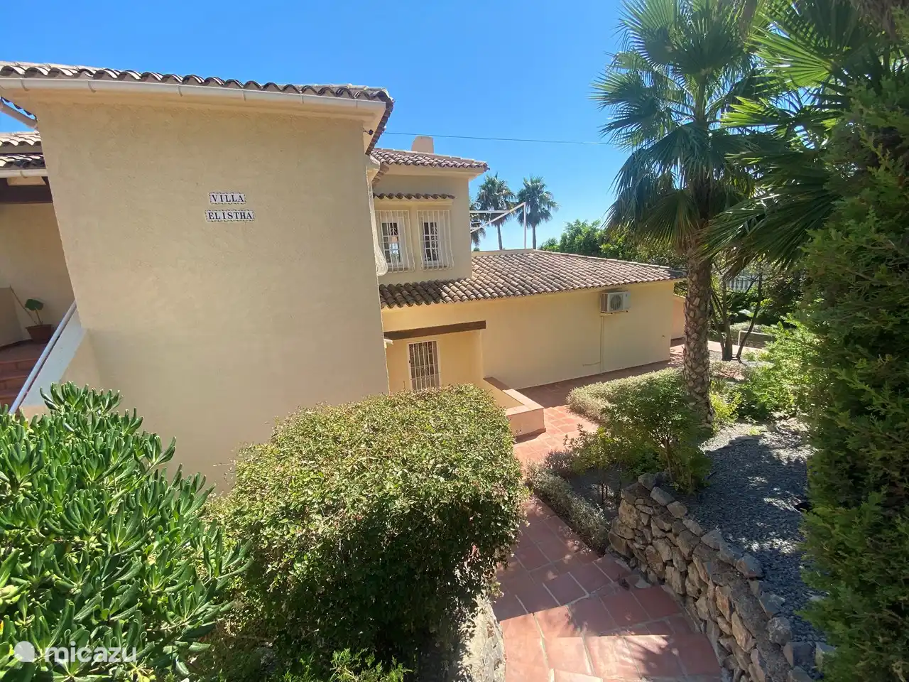 Casa delantera con jardín tropical parquizado