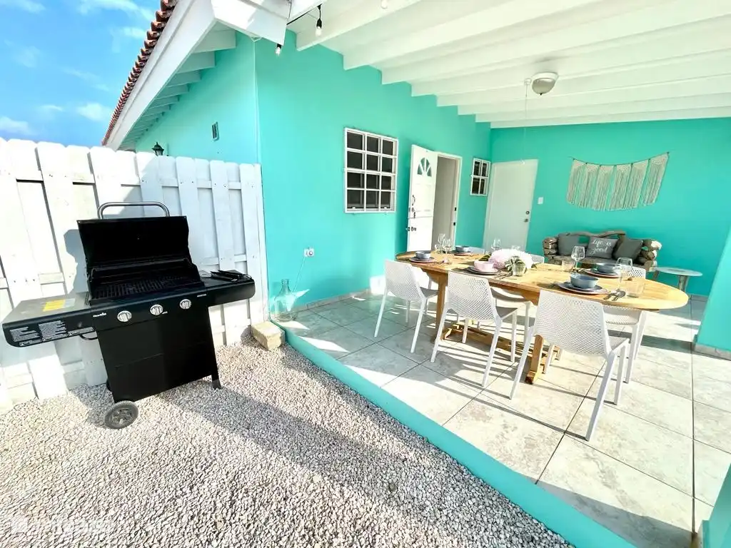 De achter porch met grote eettafel met bbq-grill.