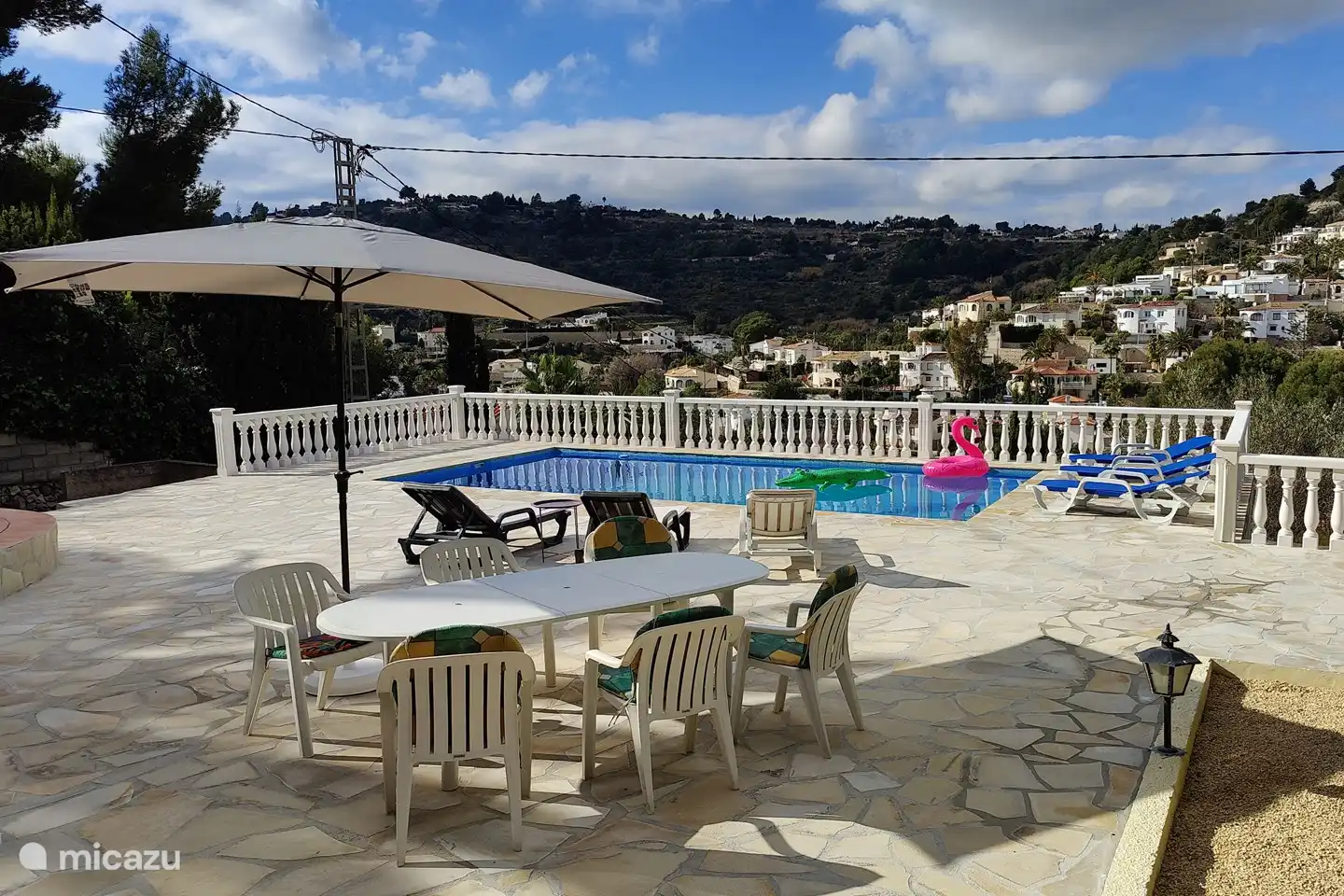 Terrasse mit Gartenmöbeln, Sonnenschirm und Sonnenliegen