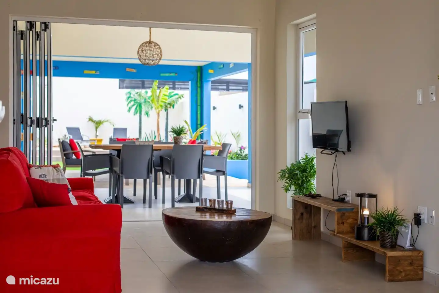 Zurück Wohnzimmer mit Schiebetüren mit Blick auf den Garten und die überdachte Terrasse.