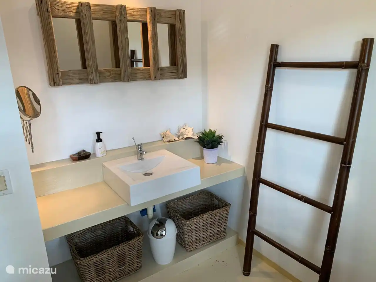 Lavabo segundo dormitorio, la madera del espejo es la superficie en las tomas de las botellas de oxígeno de buceo.