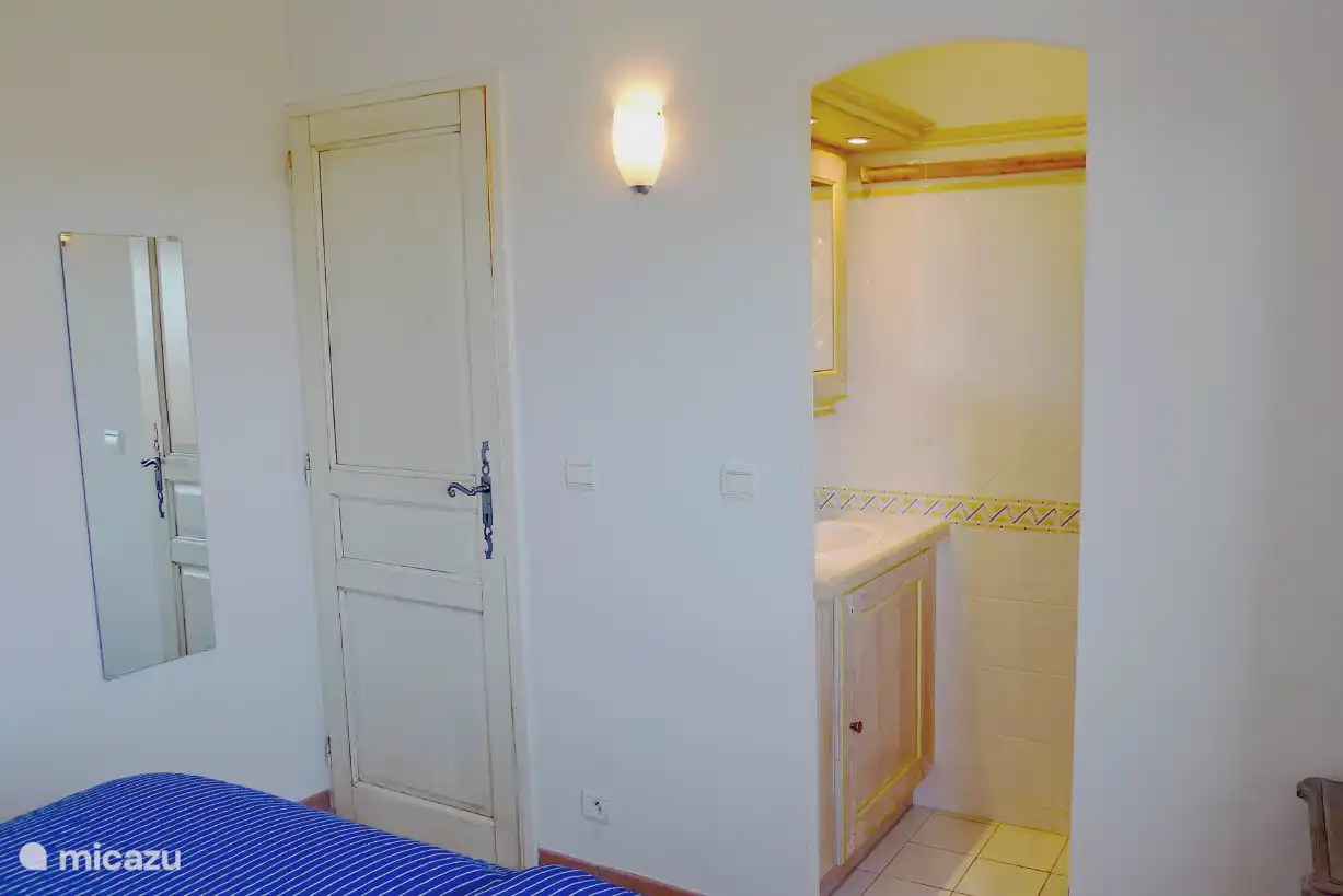 Schlafzimmer mit angrenzender Dusche und Waschbecken