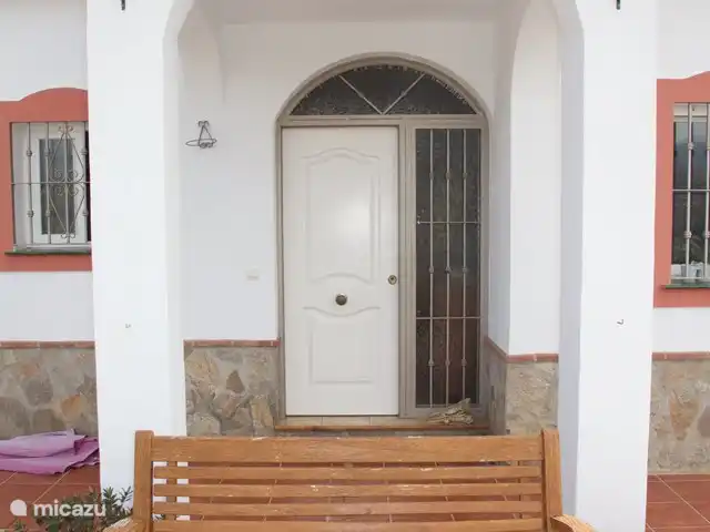 El Gato Sonriente en España, Andalucía, Cómpeta - villa La puerta de entrada con un banco delante