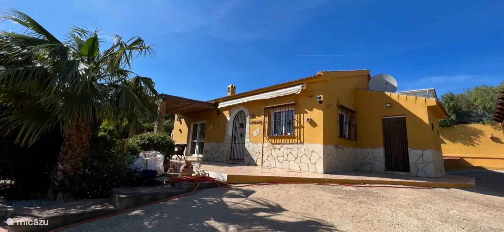 Vorderseite des Hauses mit großer Einfahrt und Carport und Blick auf den schönen Garten