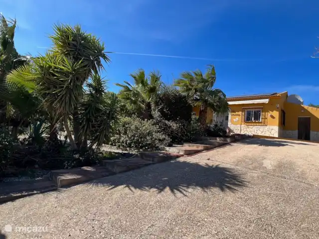Casa Katarina | Espagne, Andalousie, Alcaucin - maison de vacances Devant de la maison avec grande allée et abri d’auto et une vue sur le magnifique jardin