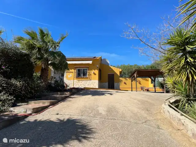 Casa Katarina | Espagne, Andalousie, Alcaucin - maison de vacances Devant de la maison avec grande allée et abri d’auto et une vue sur le magnifique jardin
