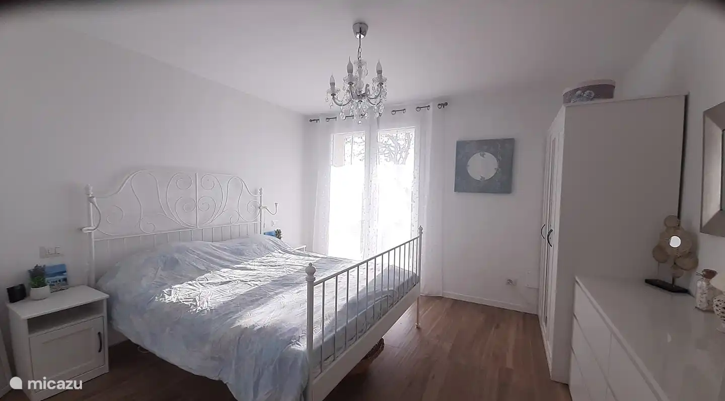 This is the master bedroom, which has 2 patio doors to the garden, which makes it a bright sunny room and partly due to the design. The terrace doors are equipped with shutters on the outside, which allow you to regulate the sunlight