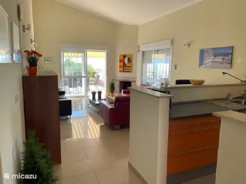 Vue d’ensemble du salon avec vue sur la terrasse et les montagnes. 