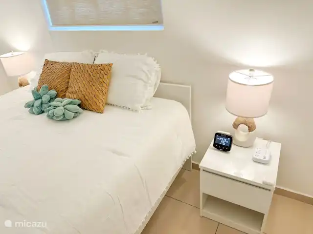 villa en Bonaire, Bonaire, Hato – villa perla Dormitorio 1. Cama matrimonial, mesita auxiliar con central eléctrica, lámparas, armario, aire acondicionado, termostato de aire acondicionado digital.