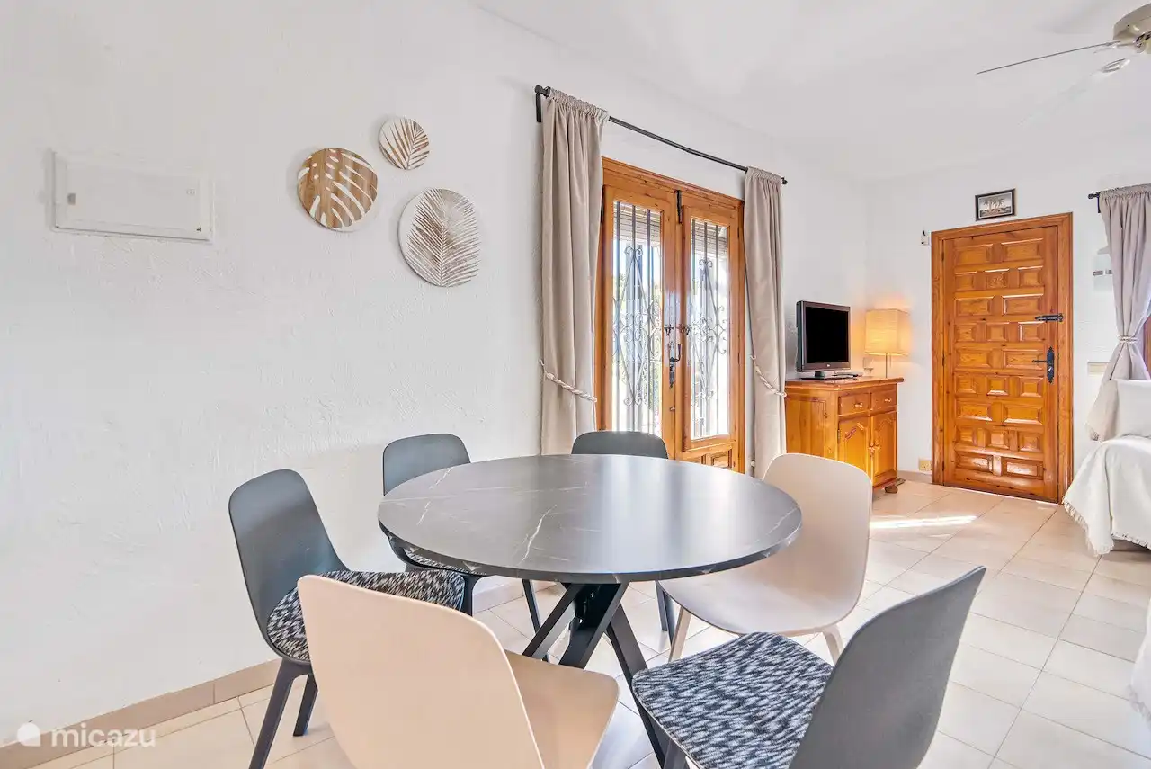 Wohnzimmer mit TV und Tür zum Balkon