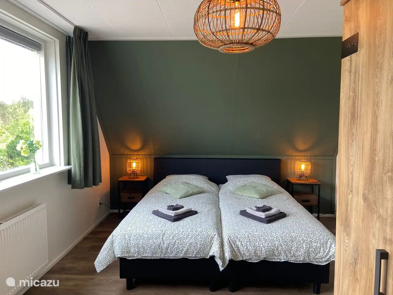 Ruime twee persoons slaapkamer, met mooie natuurlijke groentinten Grote nieuwe boxspring bedden van 210 cm x 180 cm en hygiënische hoezen. 