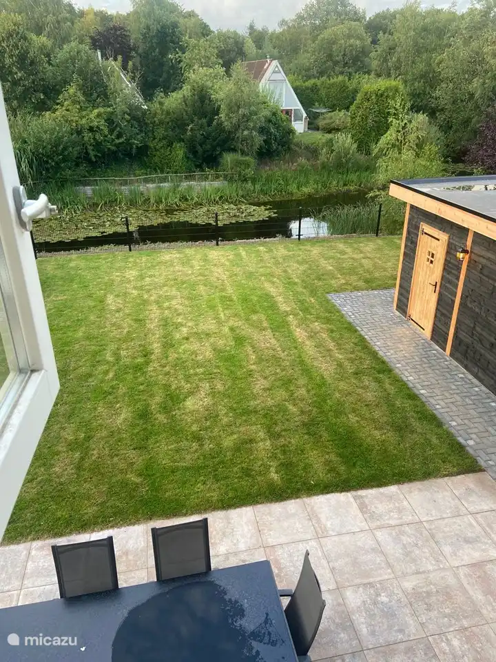 Bovenaanzicht tuin hekwerk schuurtje en vijver
