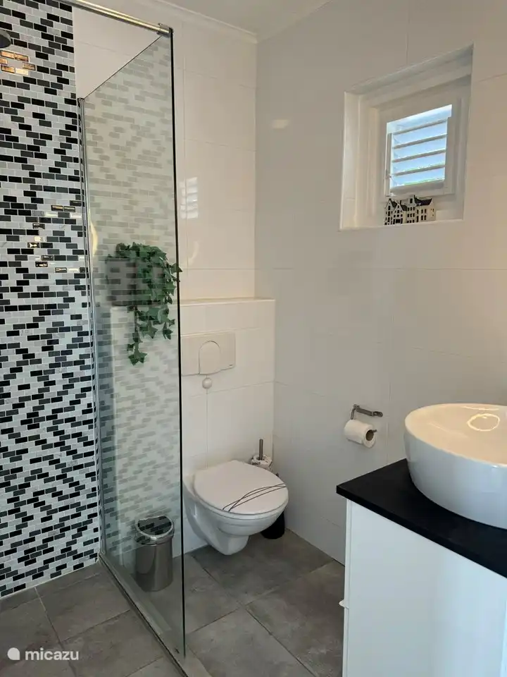 Ein eigenes Badezimmer mit Dusche, Toilette und Waschbecken für die Gästezimmer I und II.