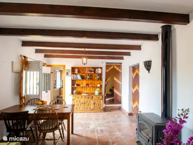 casa vacacional en España, Costa del Sol, Comares – Los Tres Gatos Comedor con estufa de leña. El material de lectura y los juegos están listos para ti.