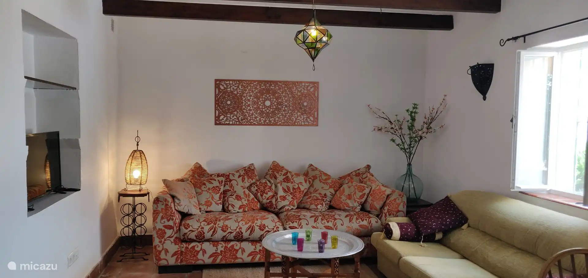 De woonkamer met comfortabele zithoek en smart-tv