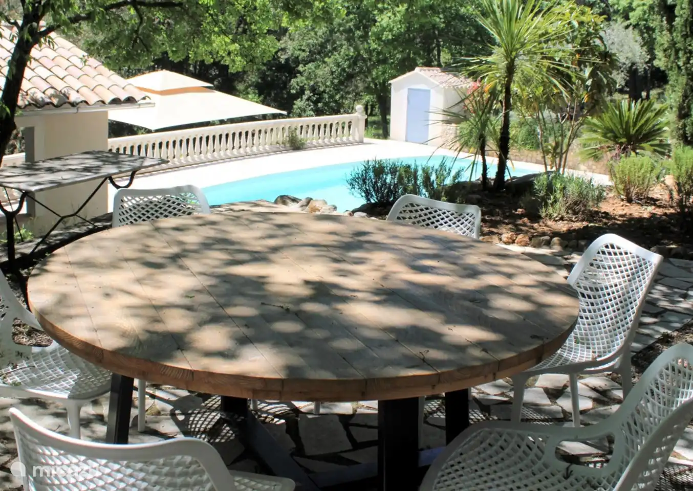 view of the pool from the seat under the trees