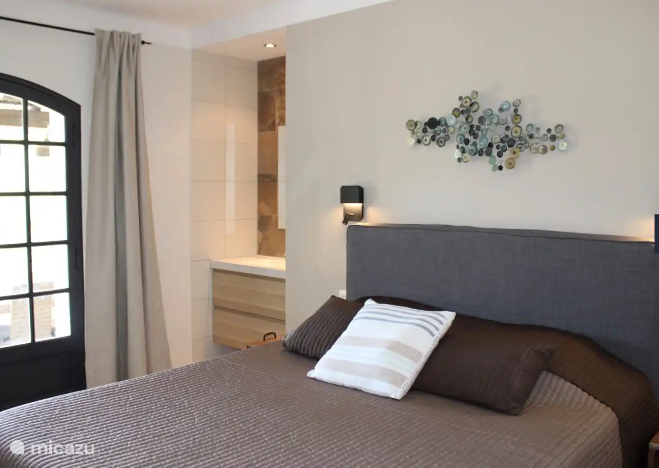 bedroom with box-spring bed, a sink and patio doors to the terrace