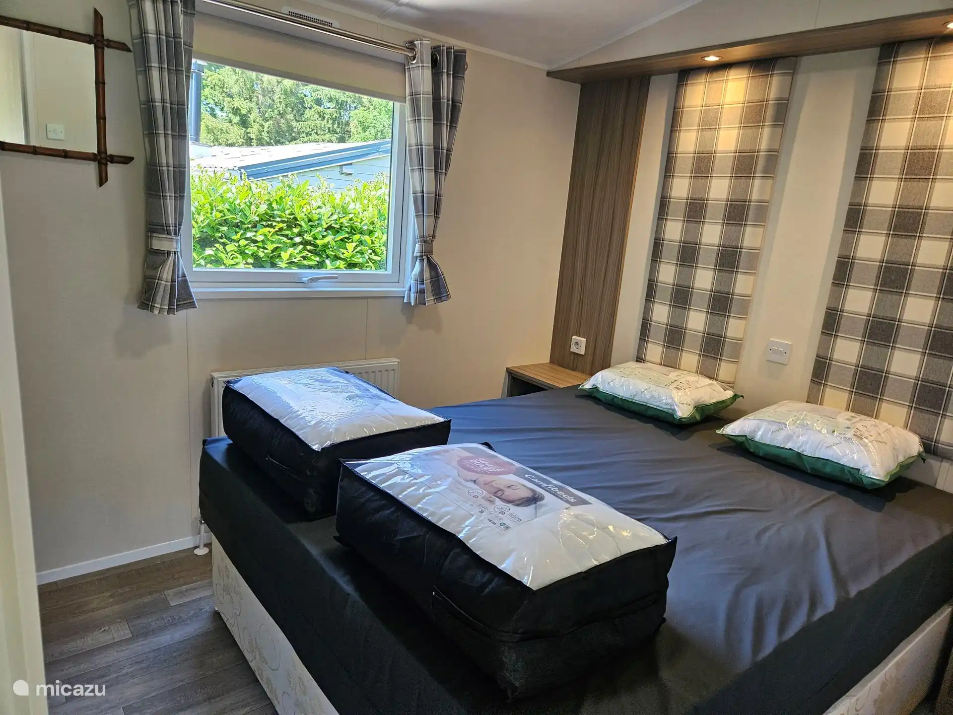 Schlafzimmer mit bequemen Boxspringbetten und zwei Einzelbettdecken