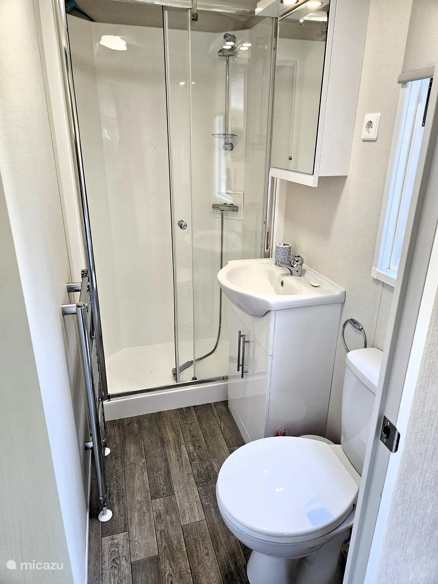 Badezimmer mit Dusche, Waschbecken und WC