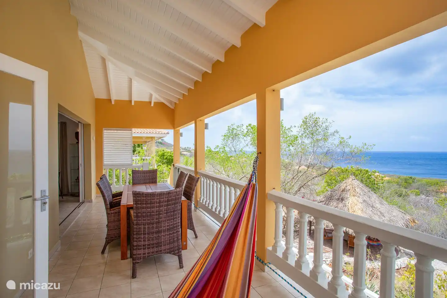 Porch with spacious dining table and hammock overlooking the Caribbean Sea