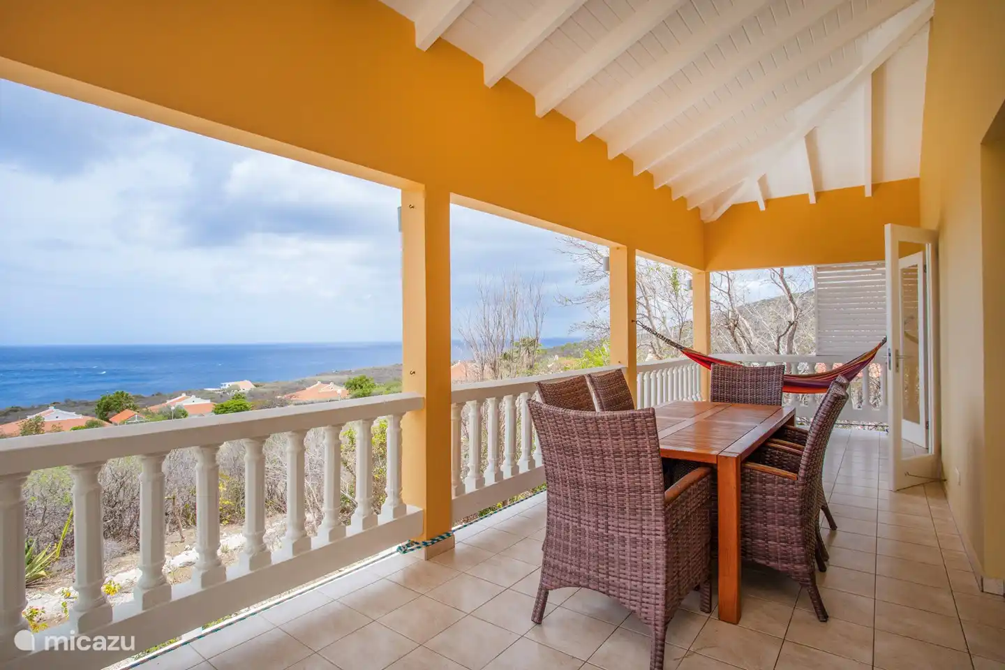 Porch with spacious dining table and hammock overlooking the Caribbean Sea